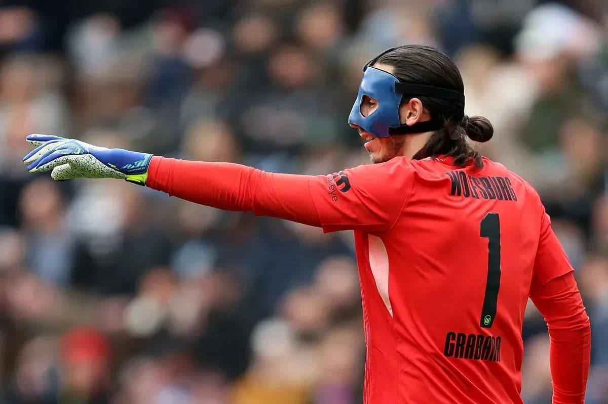 Goalkeeper in red kit directing play on field