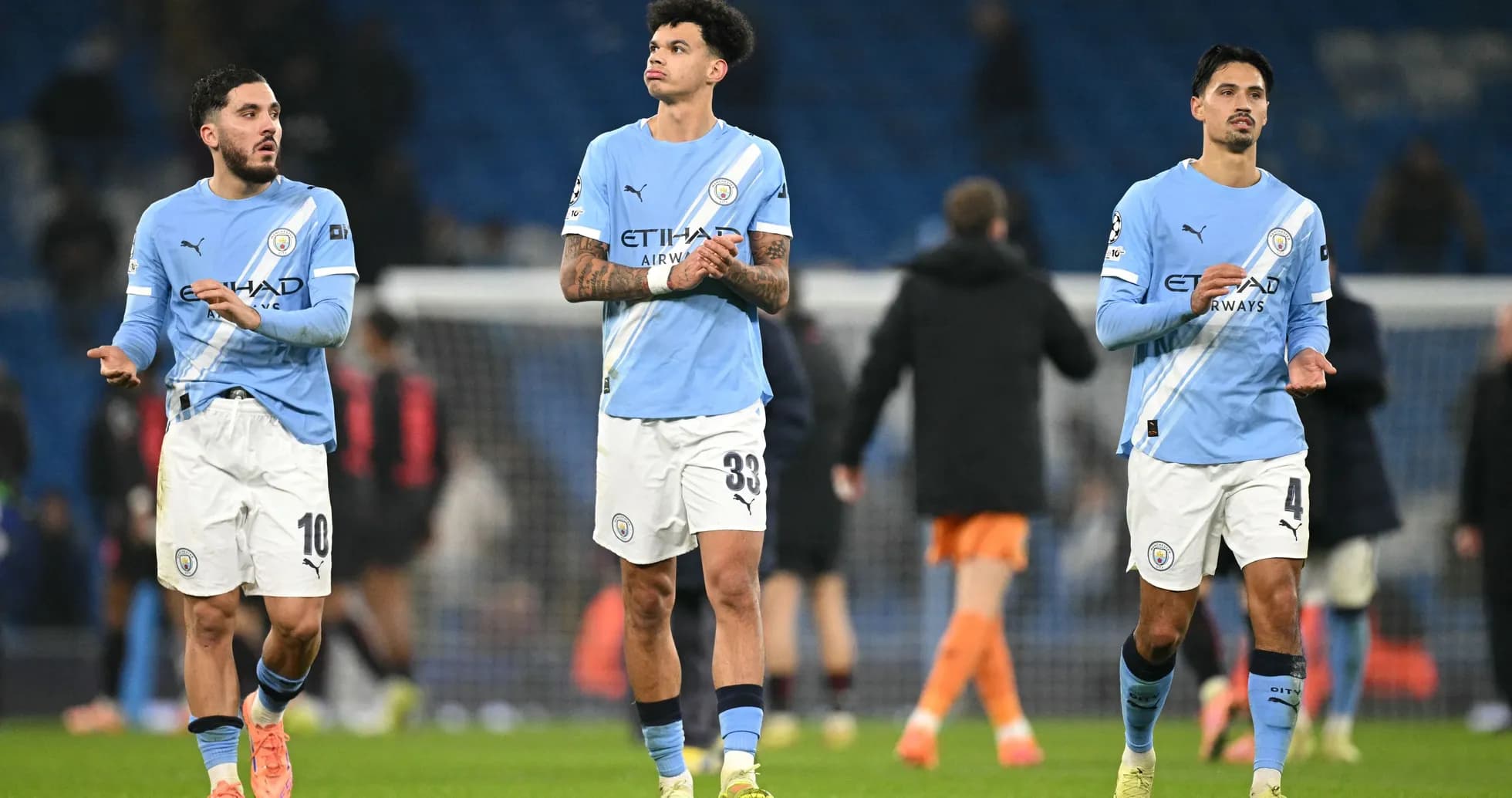 Three Manchester City players walking off the pitch