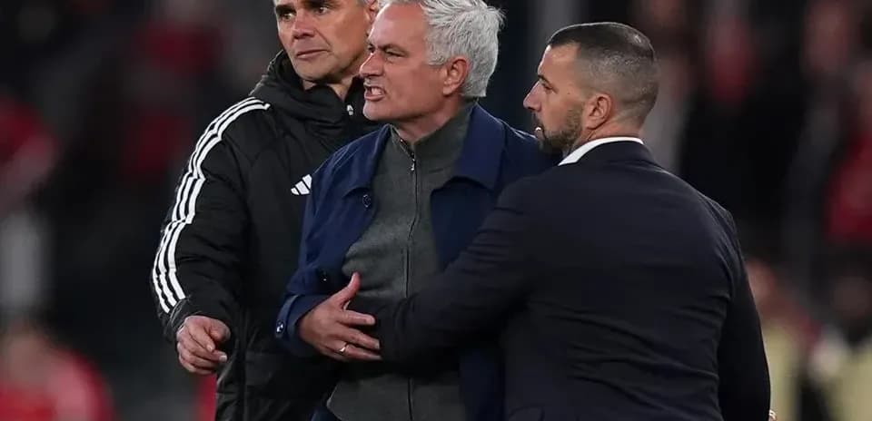 Coach being restrained during heated confrontation