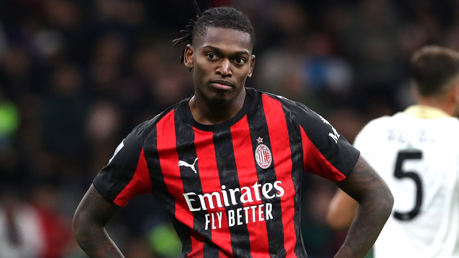 Player in AC Milan jersey on the pitch