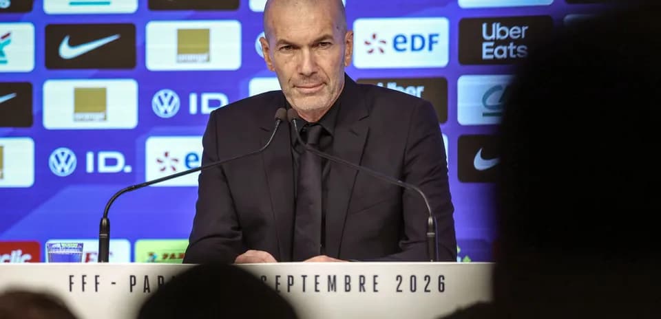 Manager speaking at press conference with sponsors backdrop