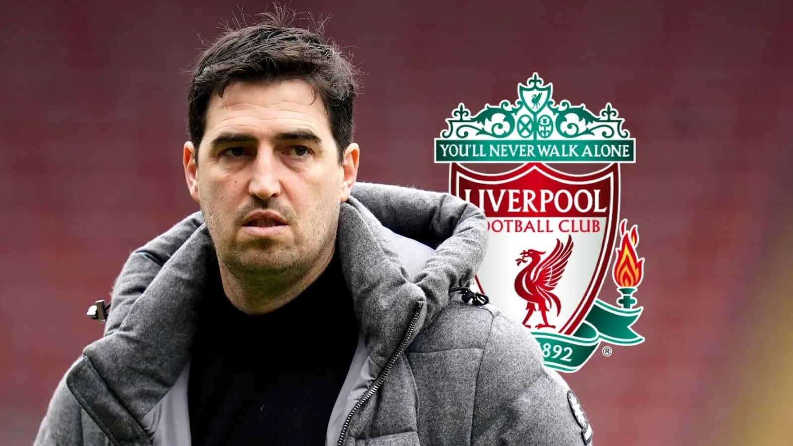 Man in jacket standing near Liverpool FC logo