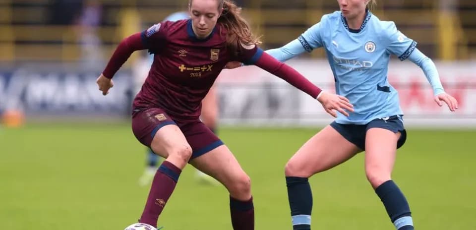 Two female players contesting the ball during match