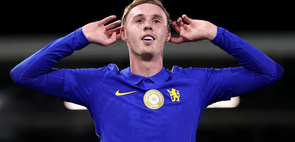 Player celebrating with hands behind ears in blue kit