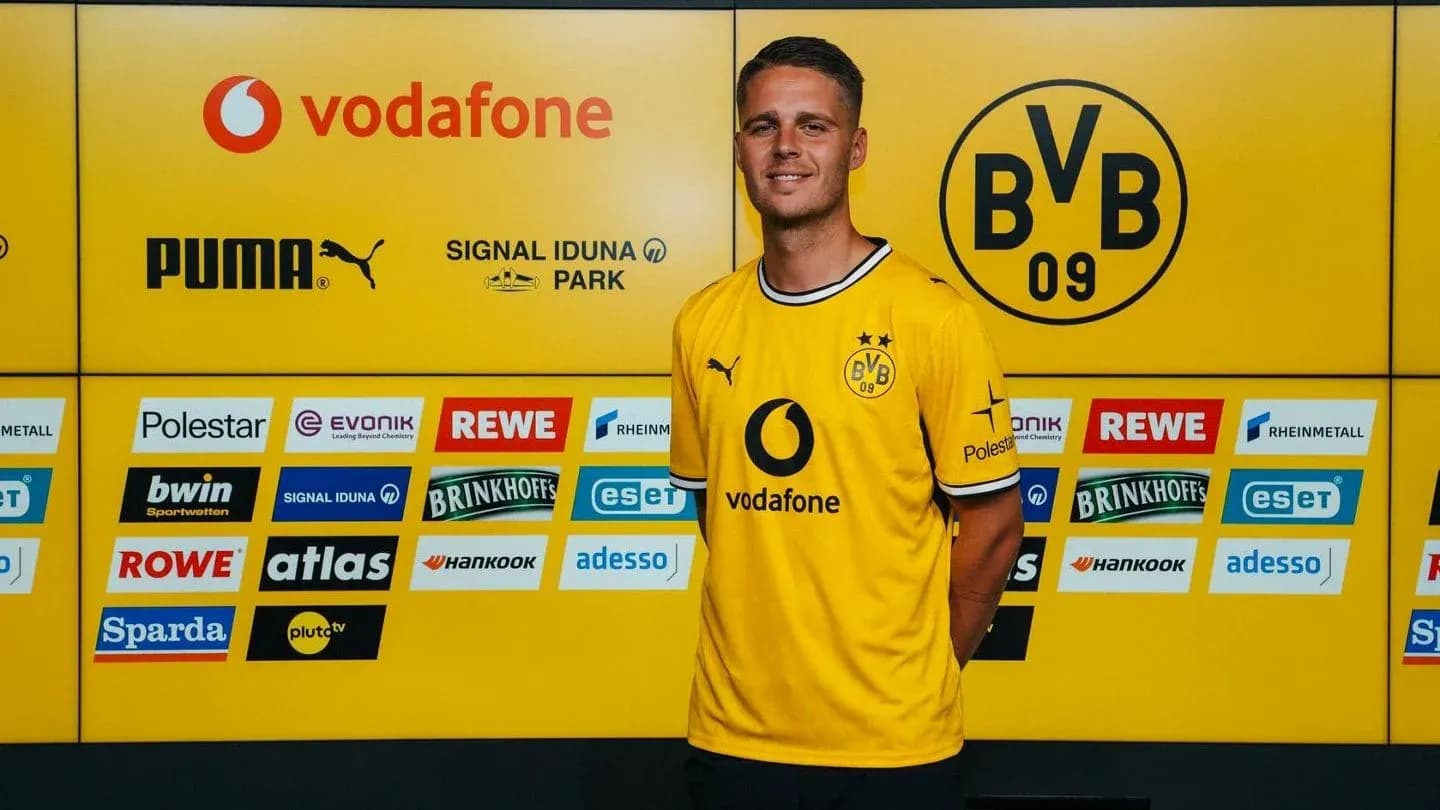 Player posing in Borussia Dortmund jersey at press event Player posing in Borussia Dortmund jersey at press event