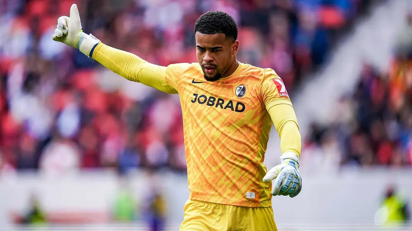 Goalkeeper signaling during a match in yellow kit Goalkeeper signaling during a match in yellow kit