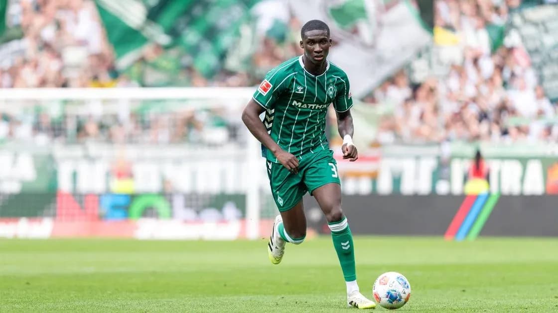 Player in green kit running on the field Player in green kit running on the field