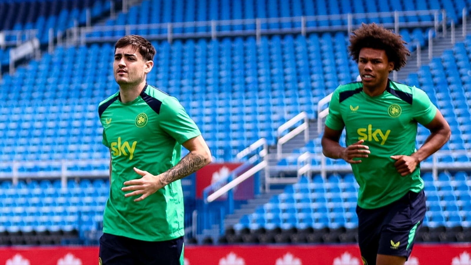 Two players jogging on the training pitch Two players jogging on the training pitch