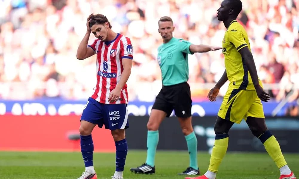 Atletico player reacting during match with referee nearby Atletico player reacting during match with referee nearby