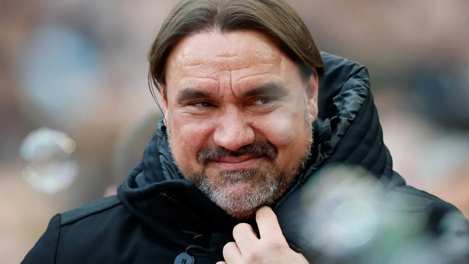 Coach in a black jacket smiling at event Coach in a black jacket smiling at event