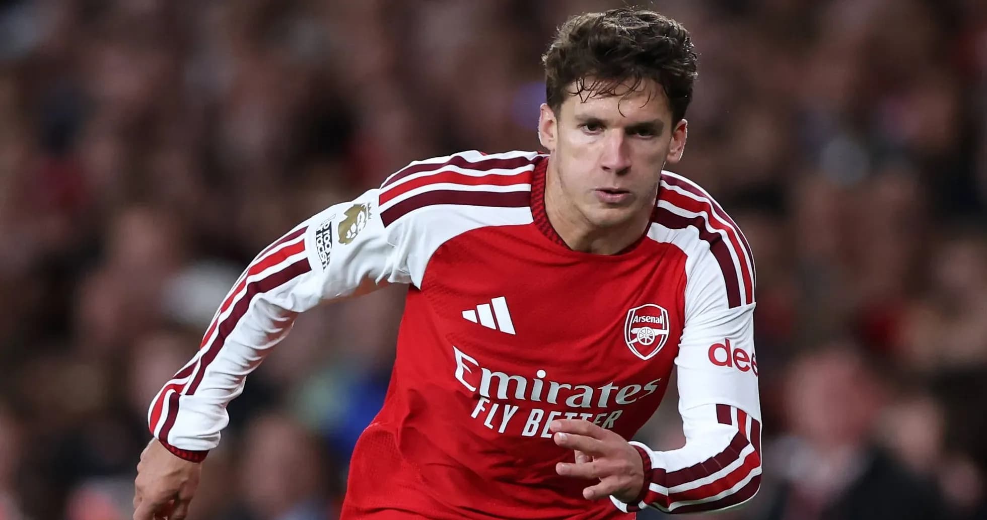 Player sprinting in Arsenal home kit during match Player sprinting in Arsenal home kit during match