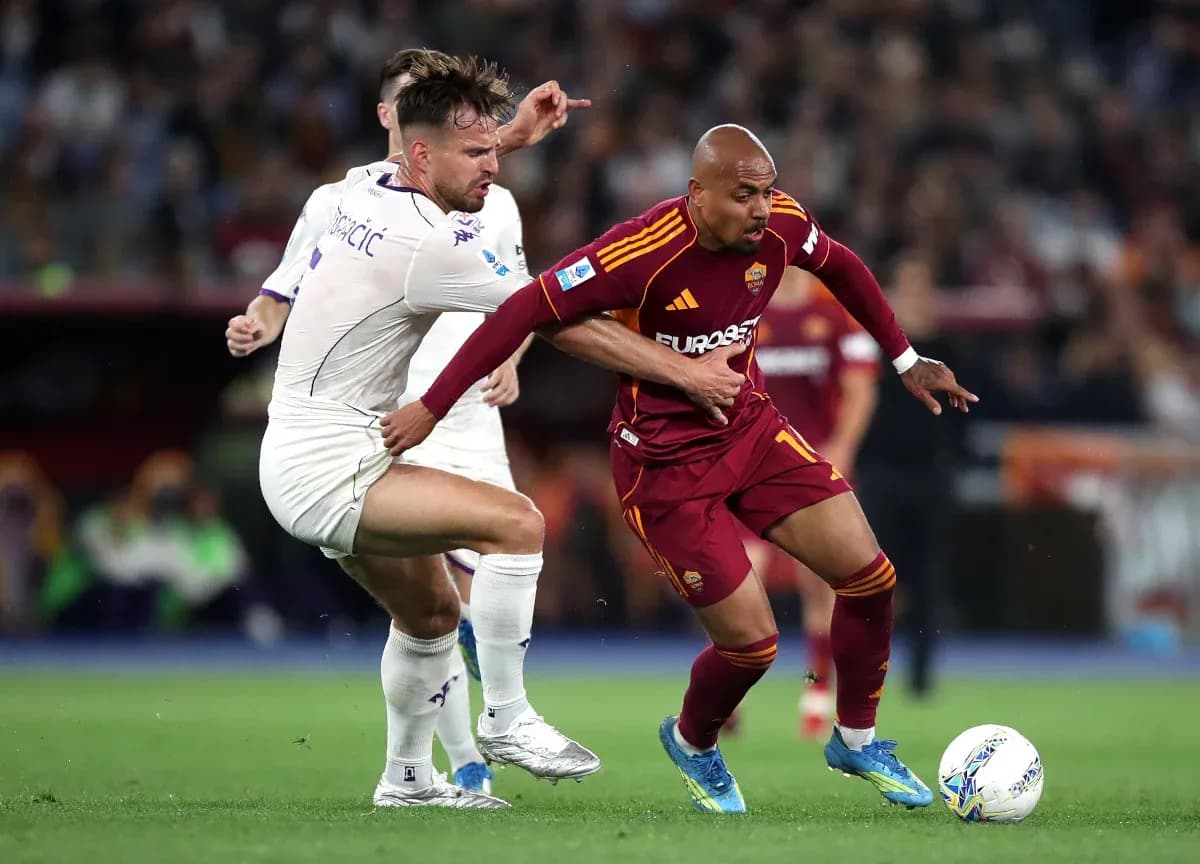 AS Roma player challenged by Fiorentina opponent AS Roma player challenged by Fiorentina opponent