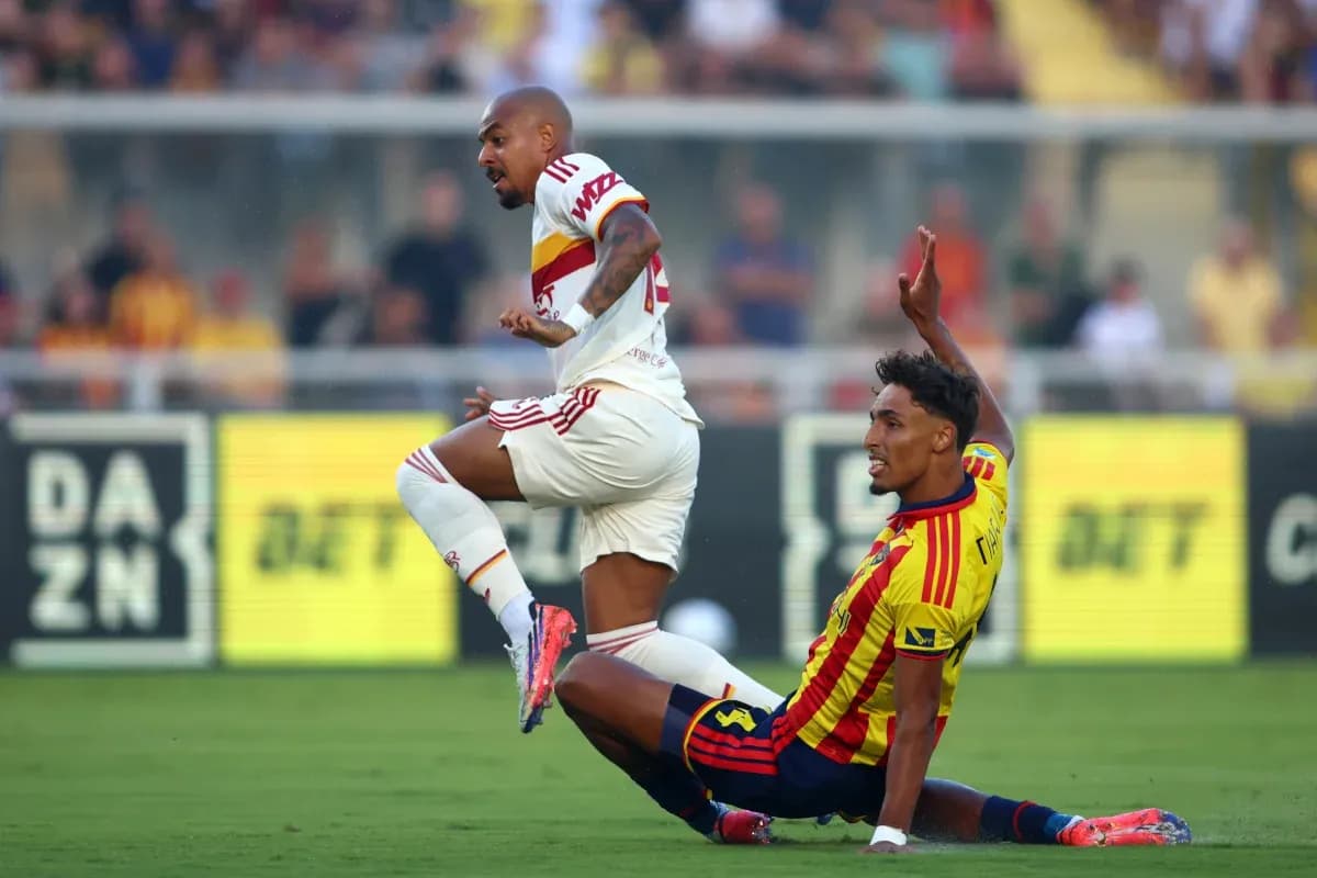 Lecce player tackles AS Roma player during match Lecce player tackles AS Roma player during match