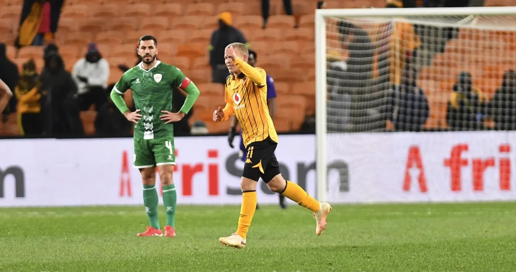 Player celebrating while opponent looks on in stadium Player celebrating while opponent looks on in stadium