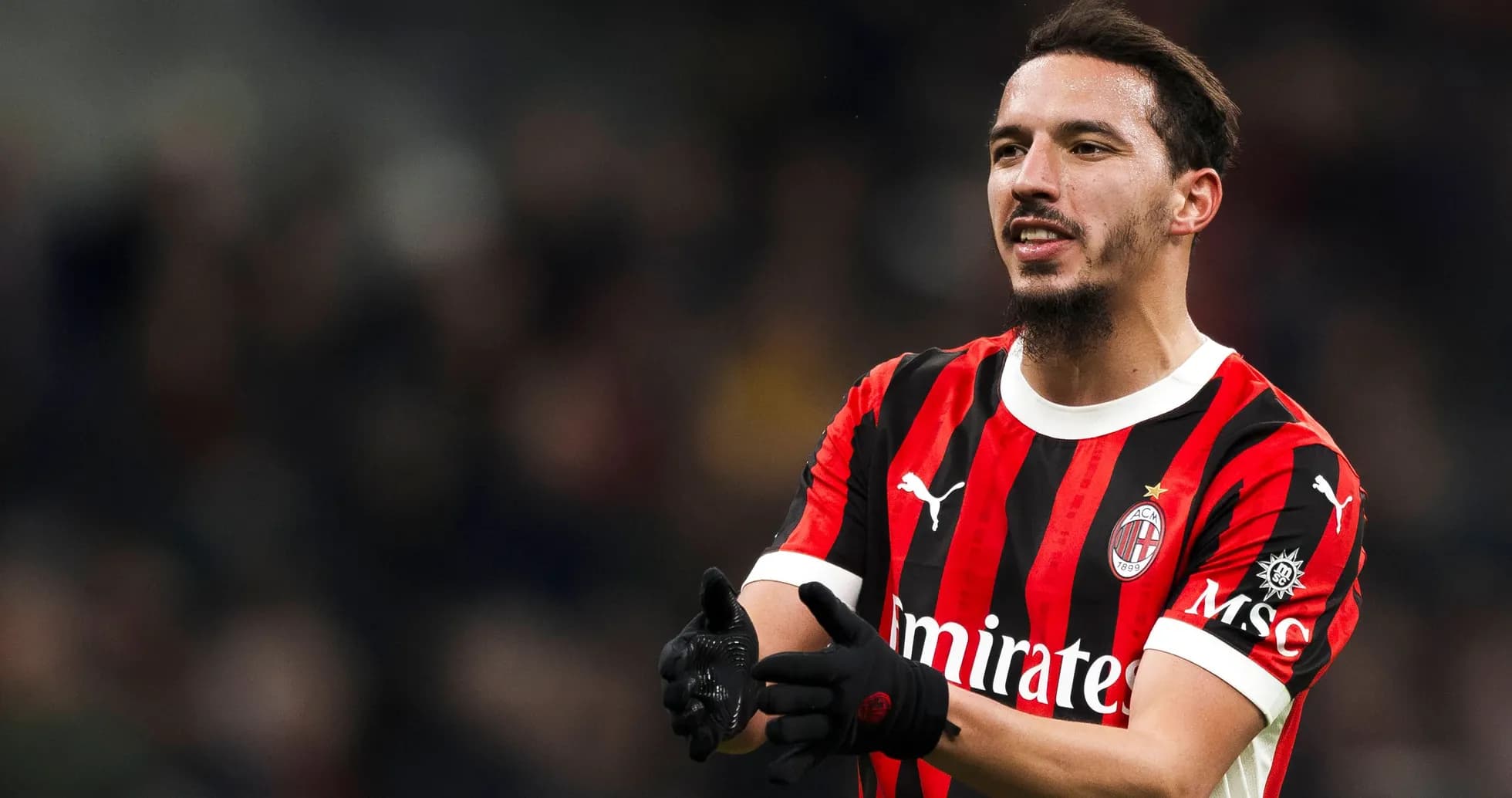 Player in AC Milan jersey celebrating on the pitch Player in AC Milan jersey celebrating on the pitch