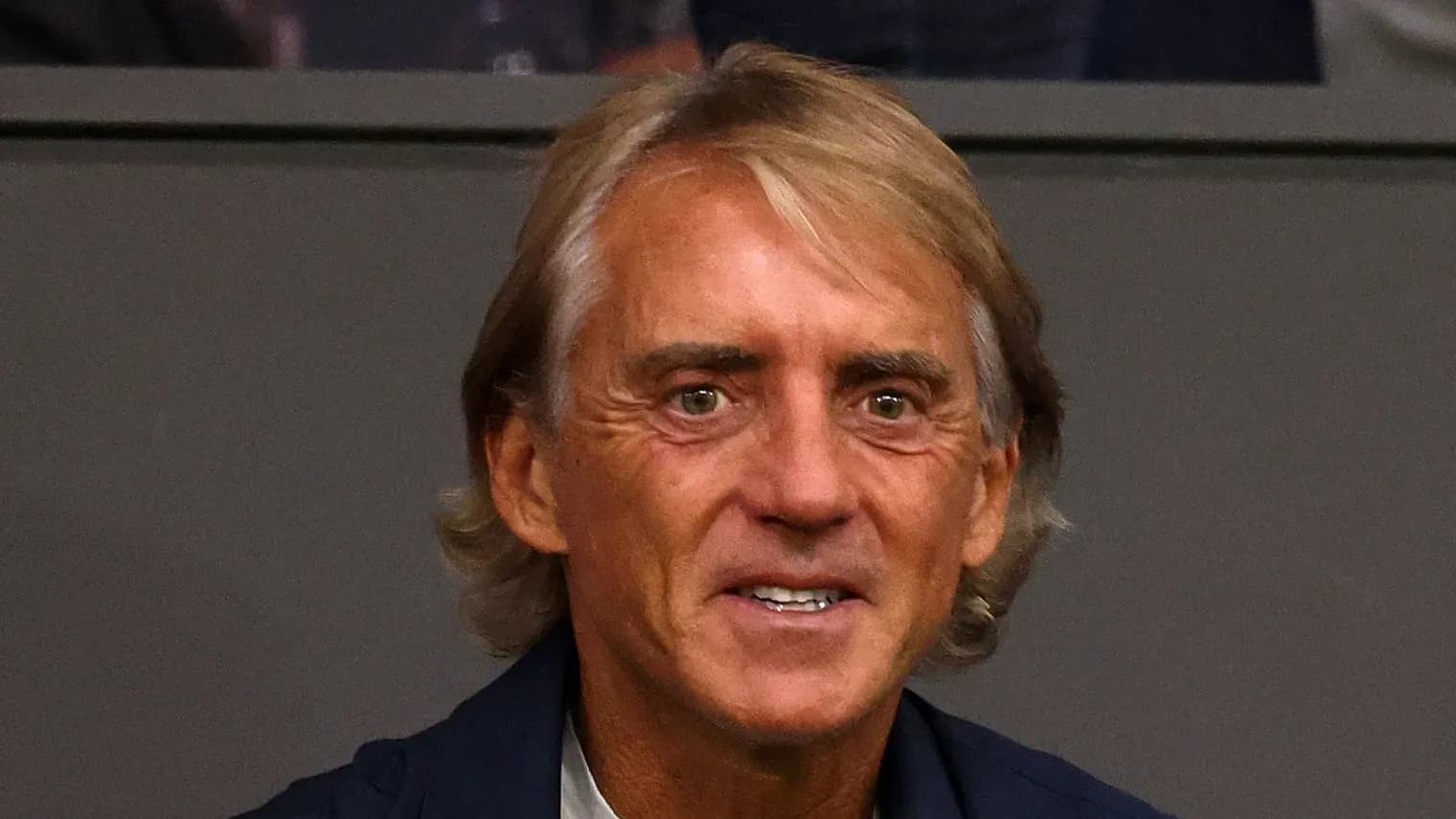 Man smiling while seated in a stadium box Man smiling while seated in a stadium box
