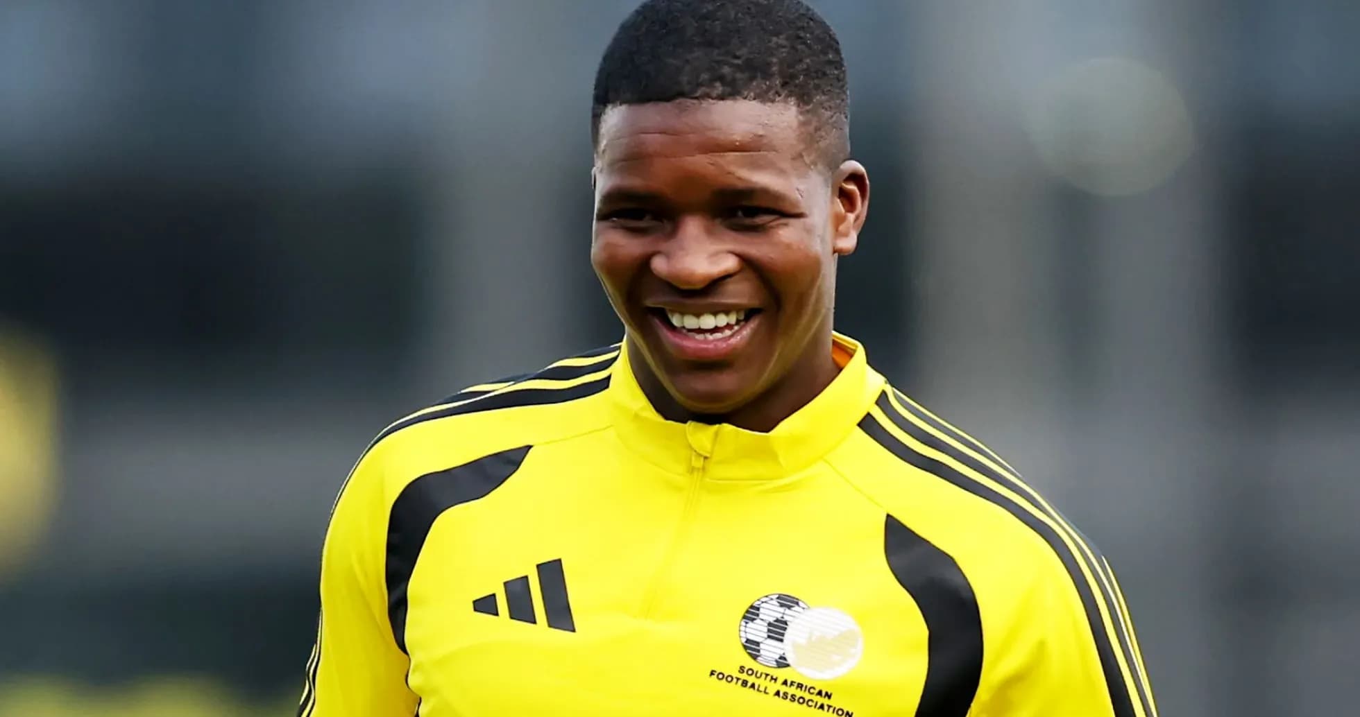 Player in yellow training kit smiling during practice Player in yellow training kit smiling during practice
