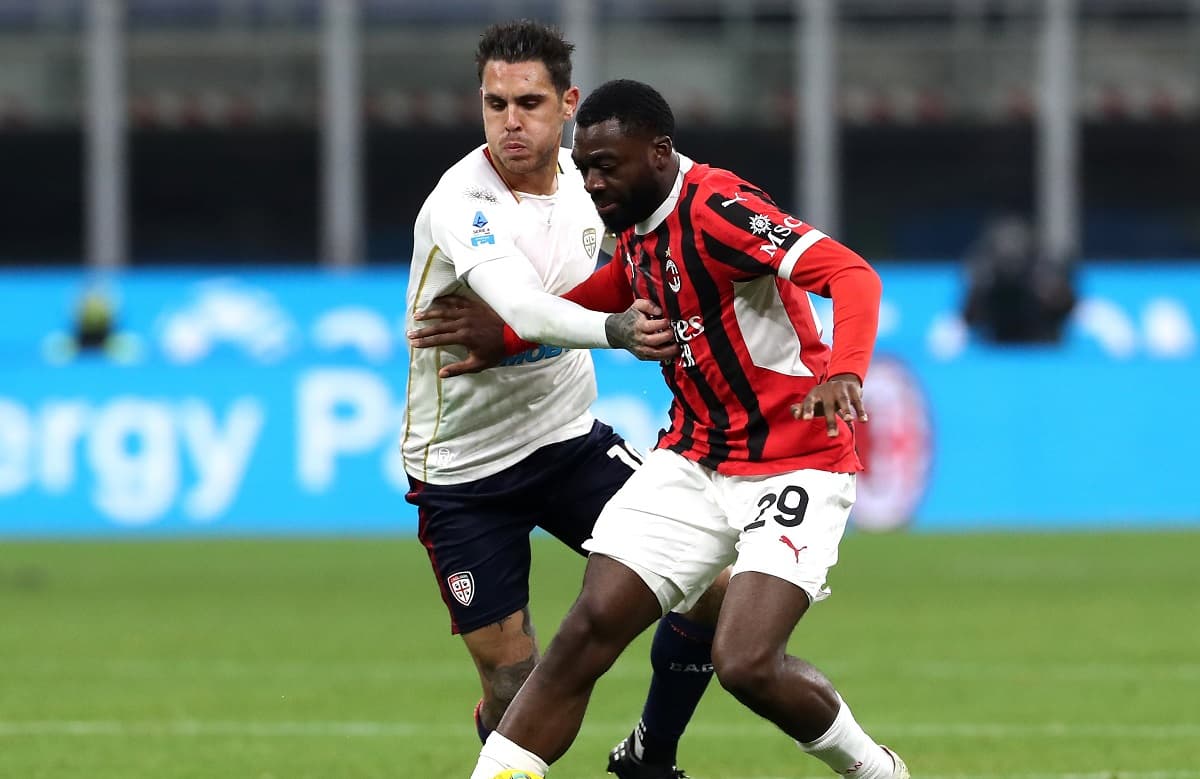 AC Milan player tackling Cagliari opponent AC Milan player tackling Cagliari opponent