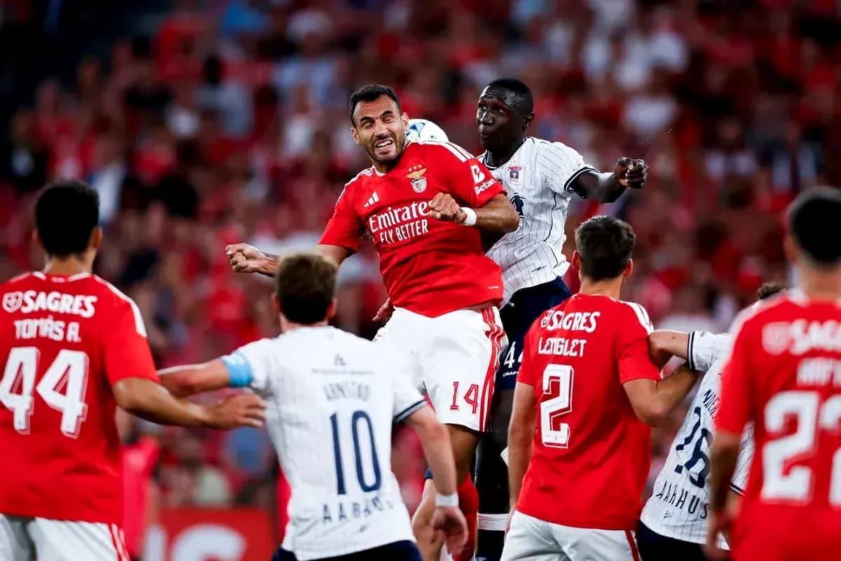 Aarhus player challenging Benfica player in match Aarhus player challenging Benfica player in match