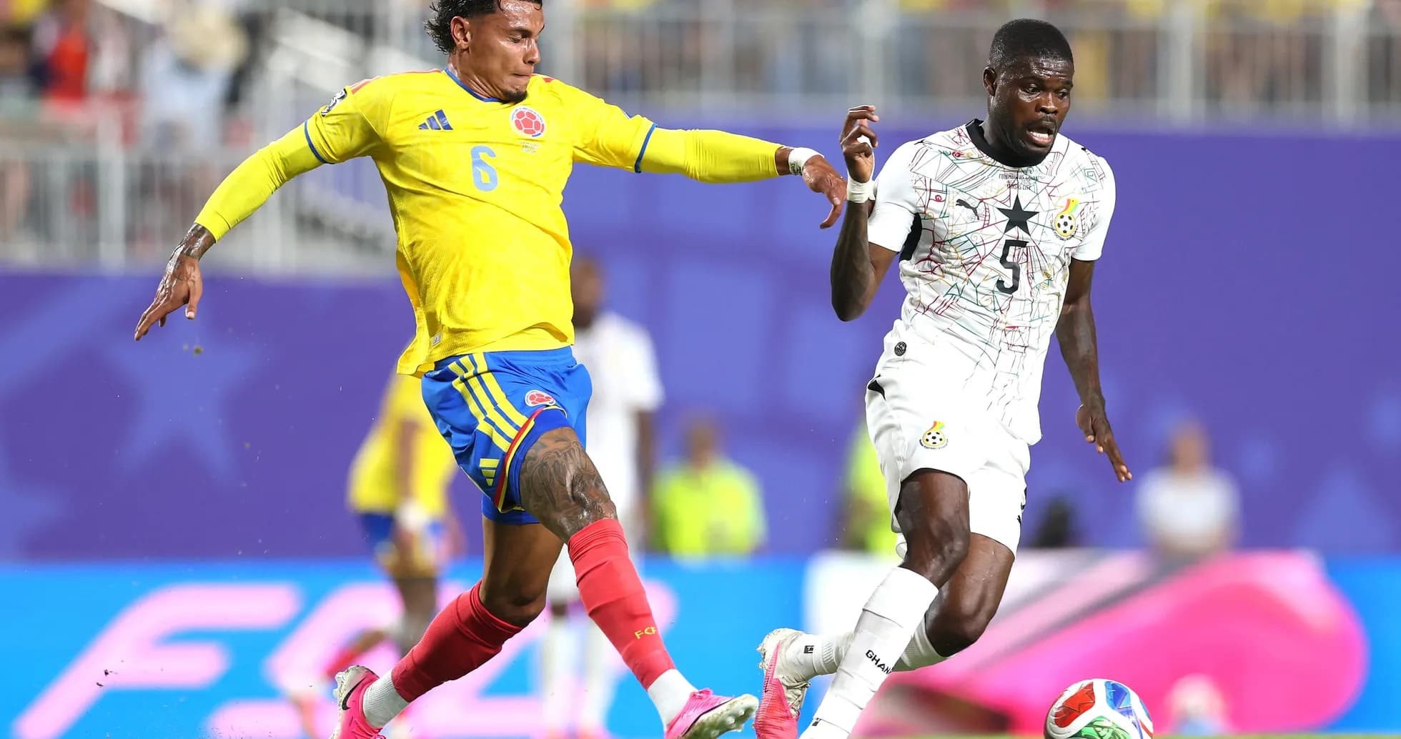 Colombia player tackles Ghana player during match Colombia player tackles Ghana player during match