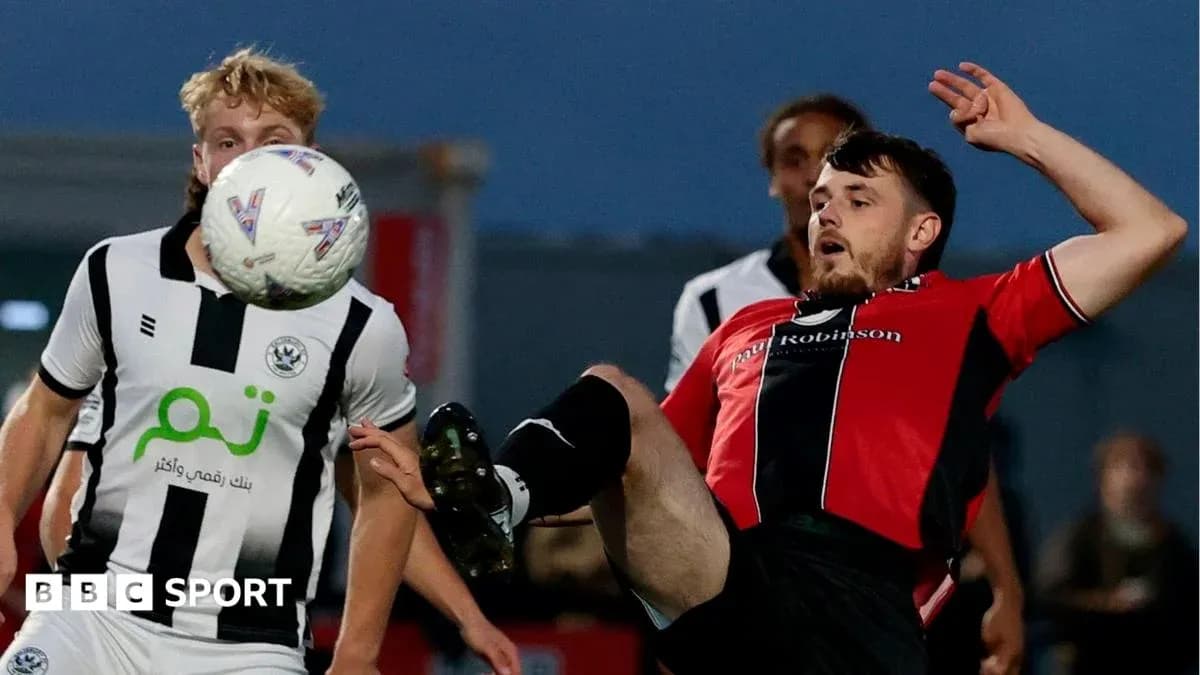 Player in red kicking ball during match action Player in red kicking ball during match action