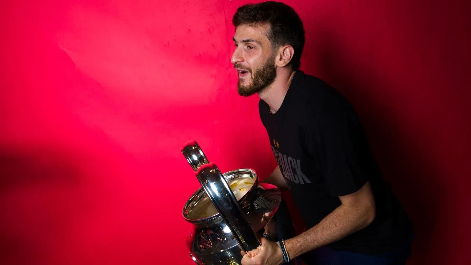 Player celebrating with a trophy against pink background Player celebrating with a trophy against pink background