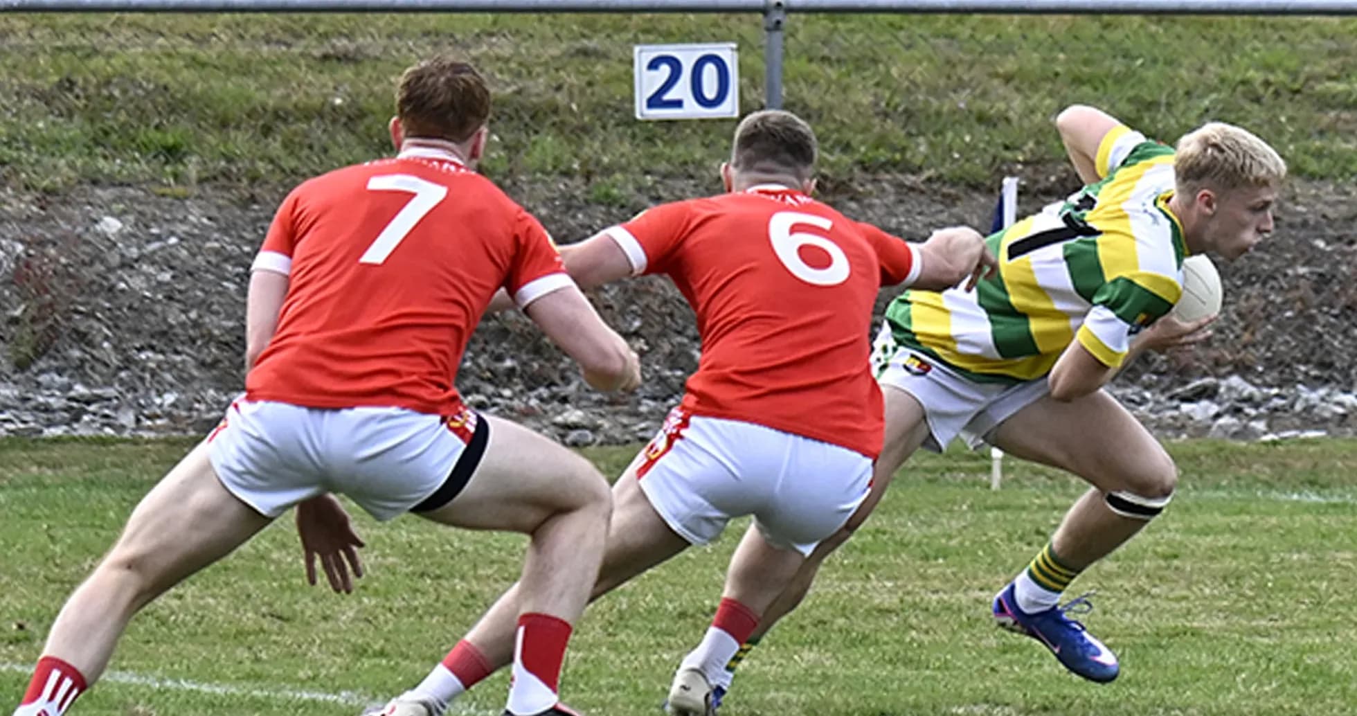 Player evading two defenders during a rugby match Player evading two defenders during a rugby match