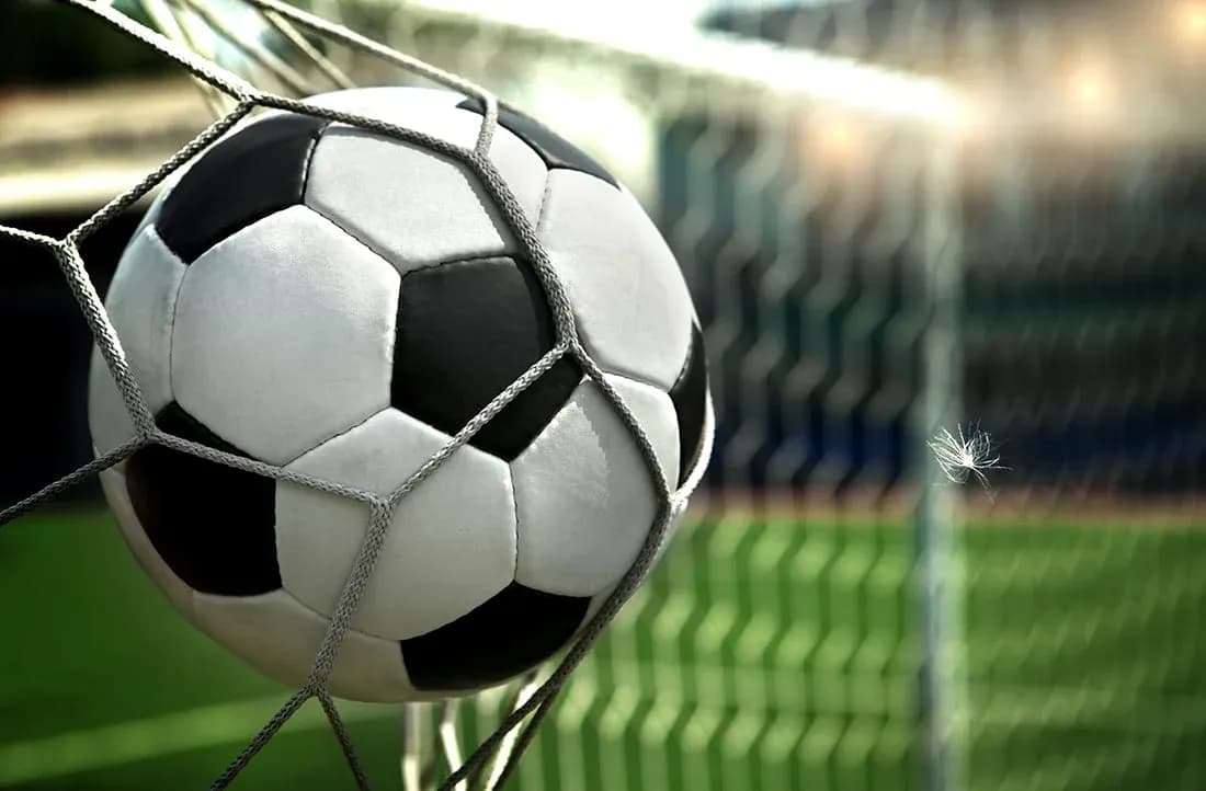 Soccer ball in goal net on field Soccer ball in goal net on field