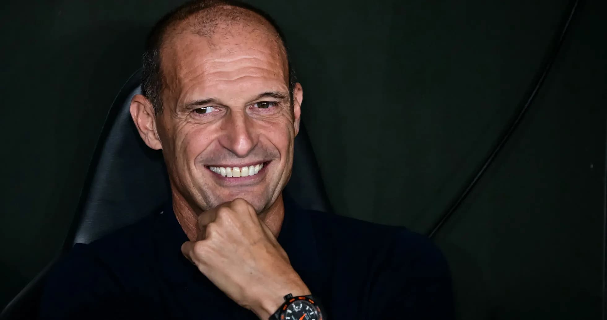 Coach smiling while seated in press conference Coach smiling while seated in press conference