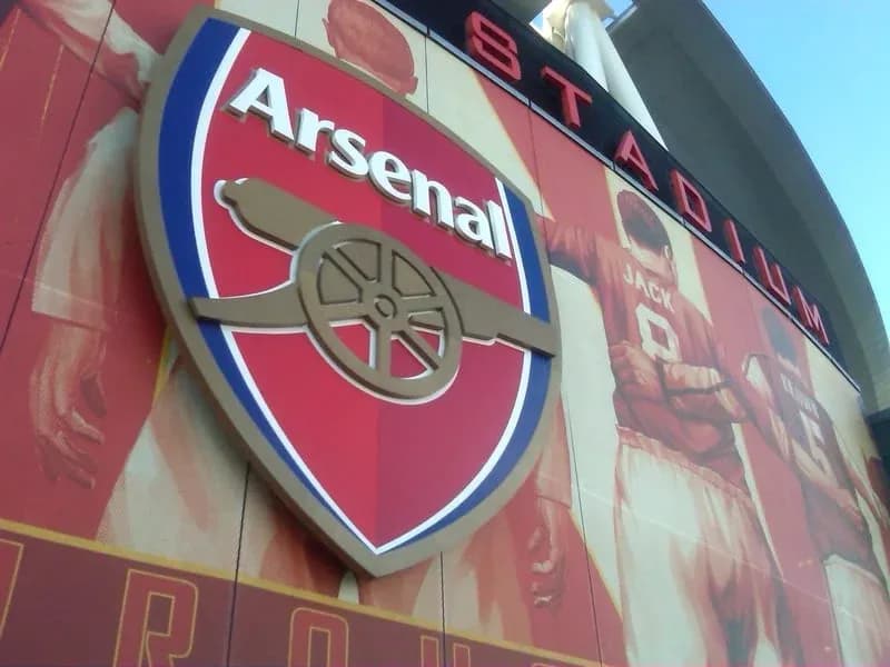 Arsenal logo on stadium wall with player mural Arsenal logo on stadium wall with player mural