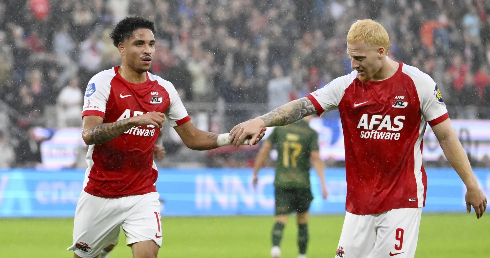 Two AZ Alkmaar players celebrating on the field Two AZ Alkmaar players celebrating on the field