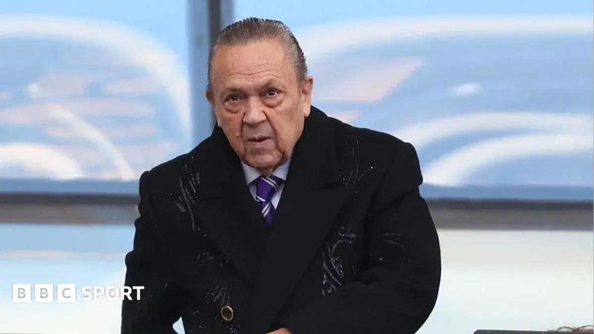 Man in black coat at sporting event venue Man in black coat at sporting event venue