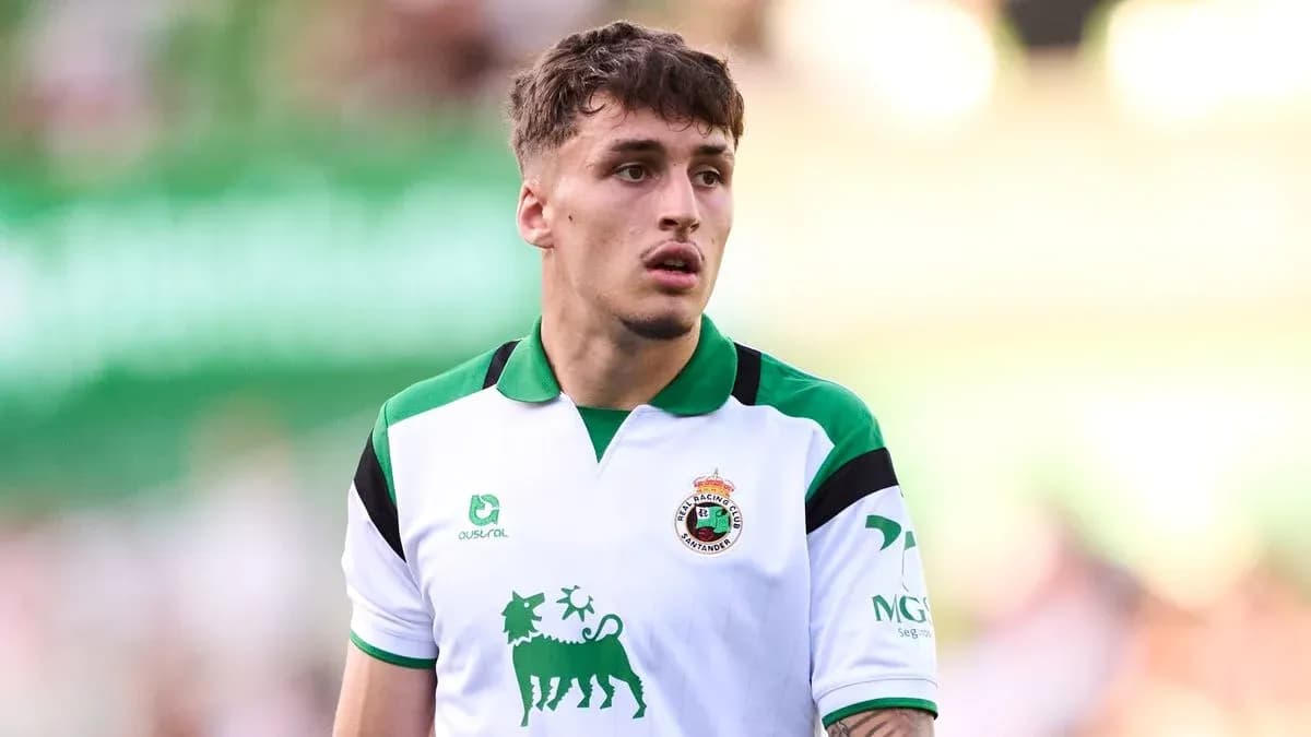 Football player wearing Racing Santander jersey on field Football player wearing Racing Santander jersey on field