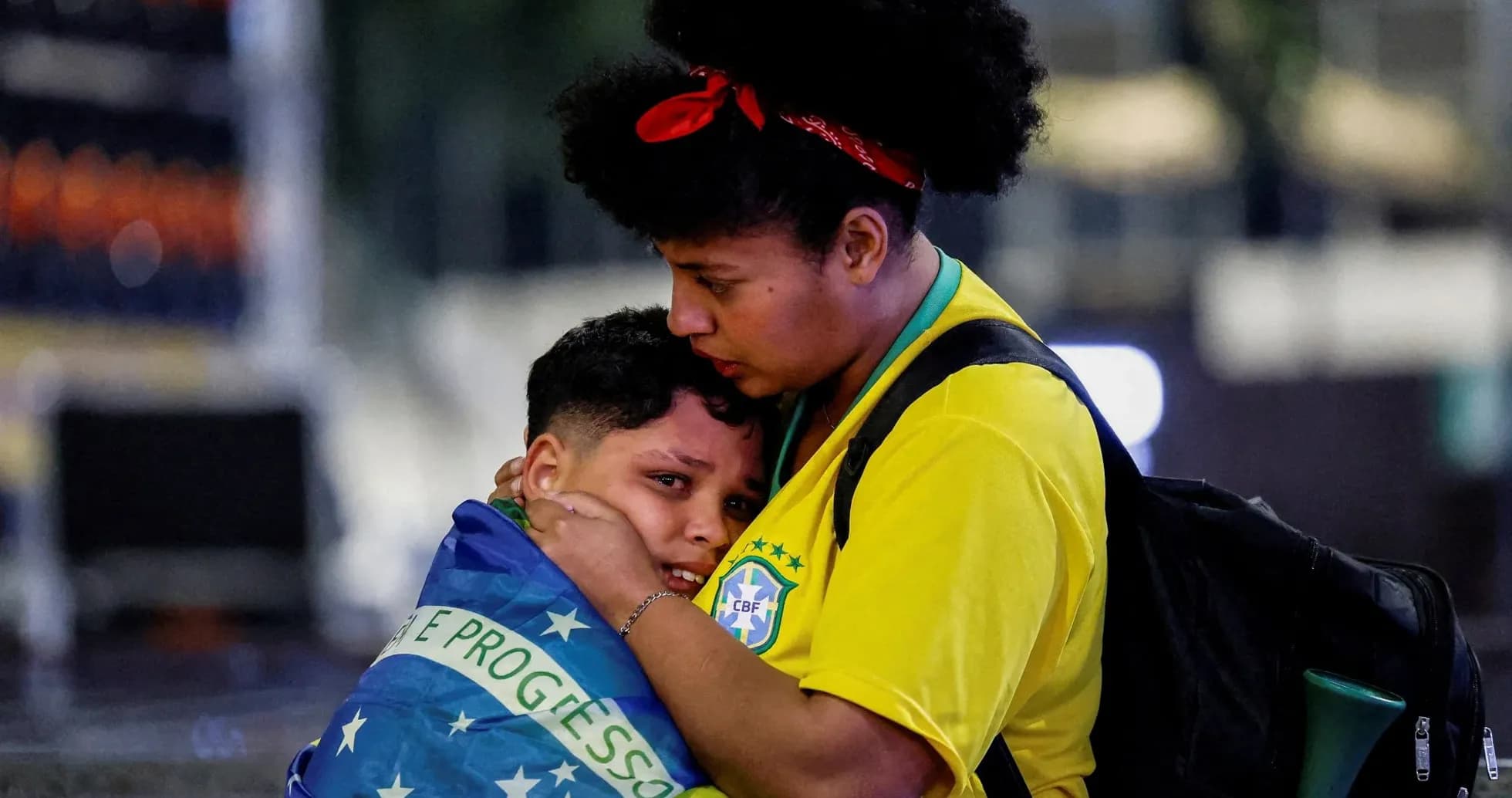Fan comforting child wrapped in Brazilian flag Fan comforting child wrapped in Brazilian flag