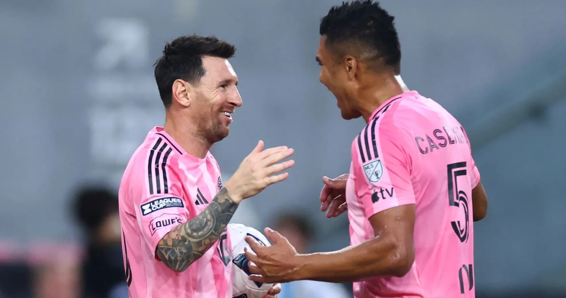 Two players celebrating a goal in pink jerseys Two players celebrating a goal in pink jerseys