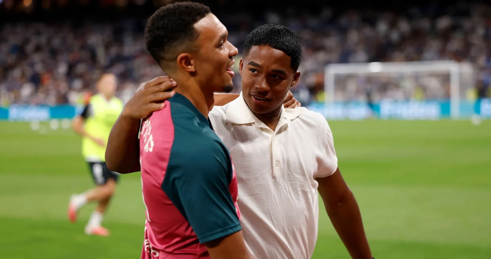 Two young men embracing on football pitch Two young men embracing on football pitch