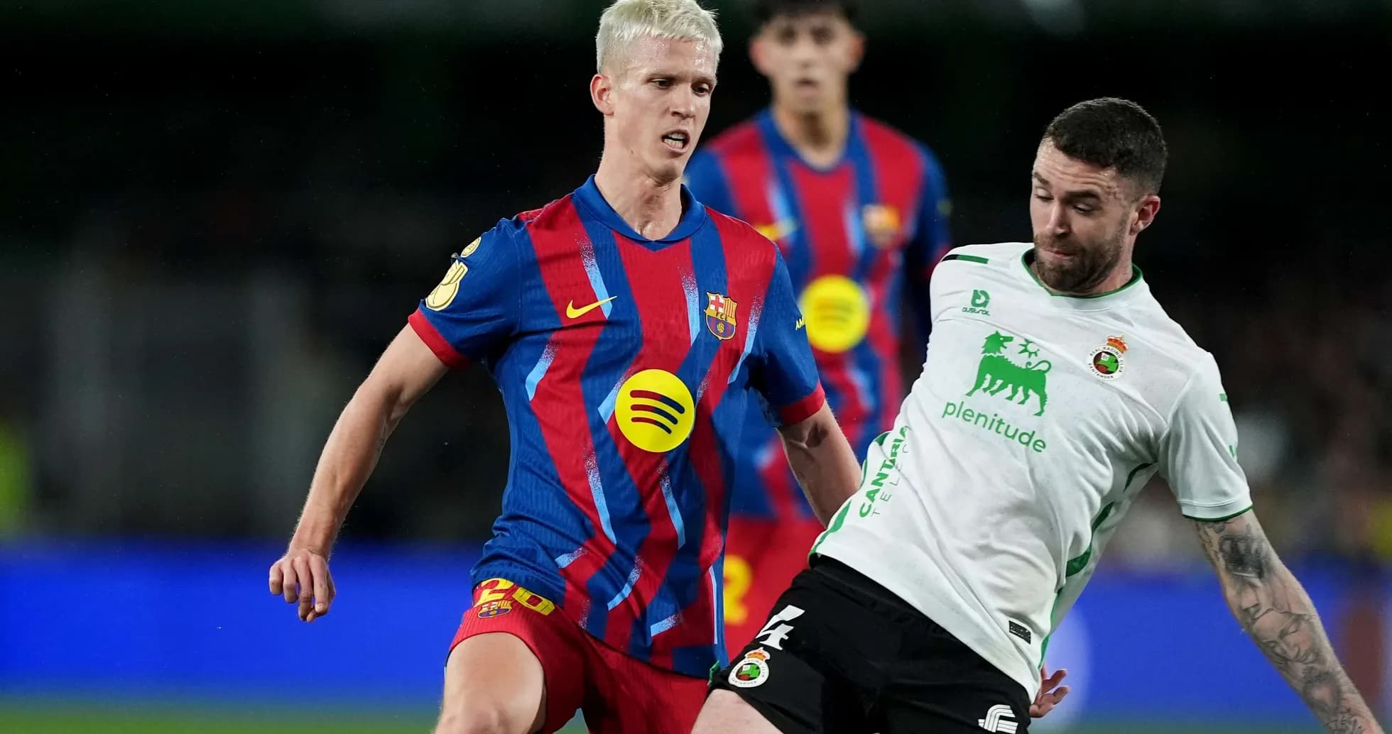 Barcelona player challenging Racing Santander opponent Barcelona player challenging Racing Santander opponent