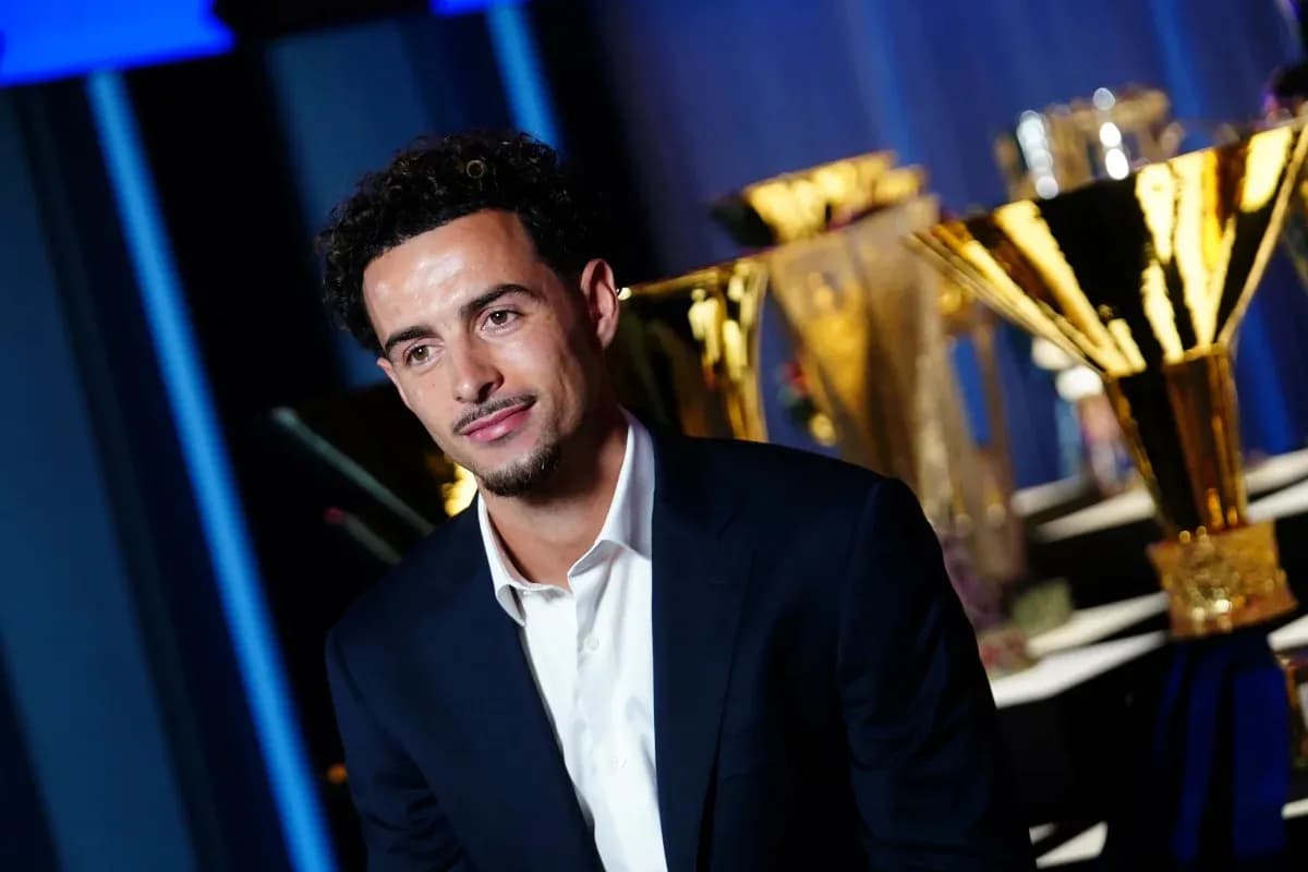 Player posing in front of trophies at event Player posing in front of trophies at event