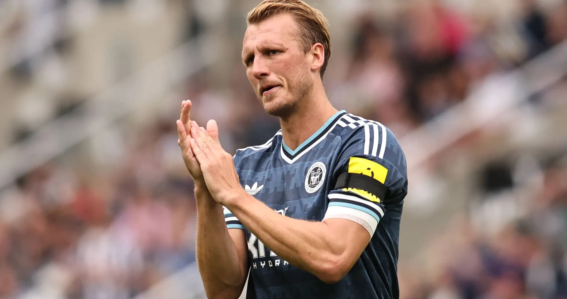 Player applauding fans while wearing captain's armband Player applauding fans while wearing captain's armband