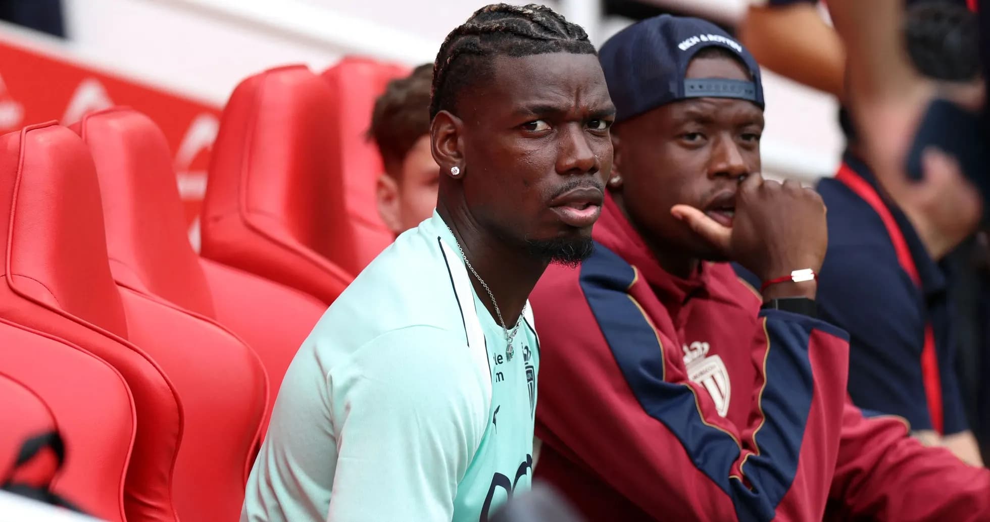 Two players sitting on red benches at stadium Two players sitting on red benches at stadium
