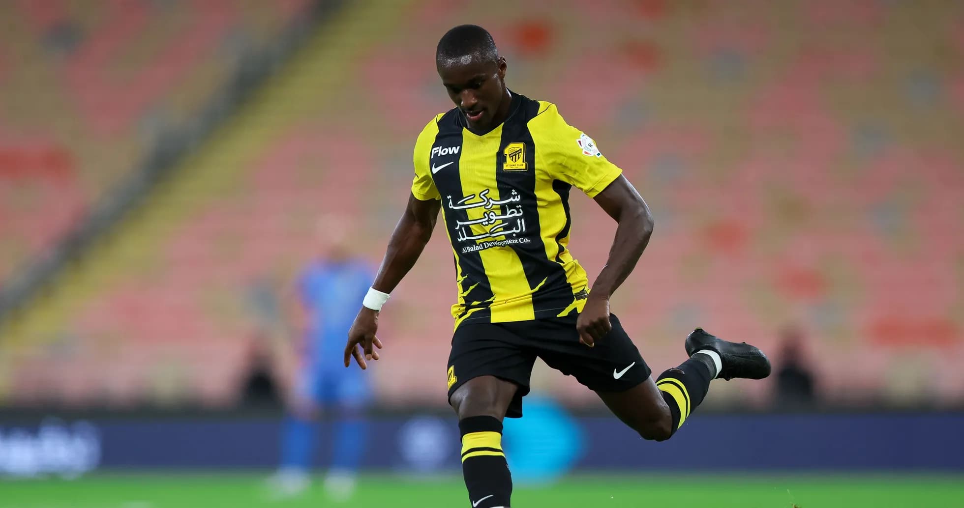 Player in black and yellow kit kicking soccer ball Player in black and yellow kit kicking soccer ball