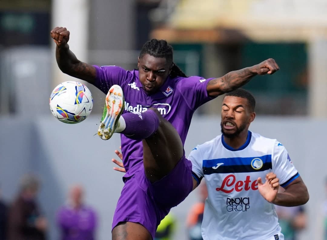 Fiorentina player kicking ball against Atalanta opponent Fiorentina player kicking ball against Atalanta opponent
