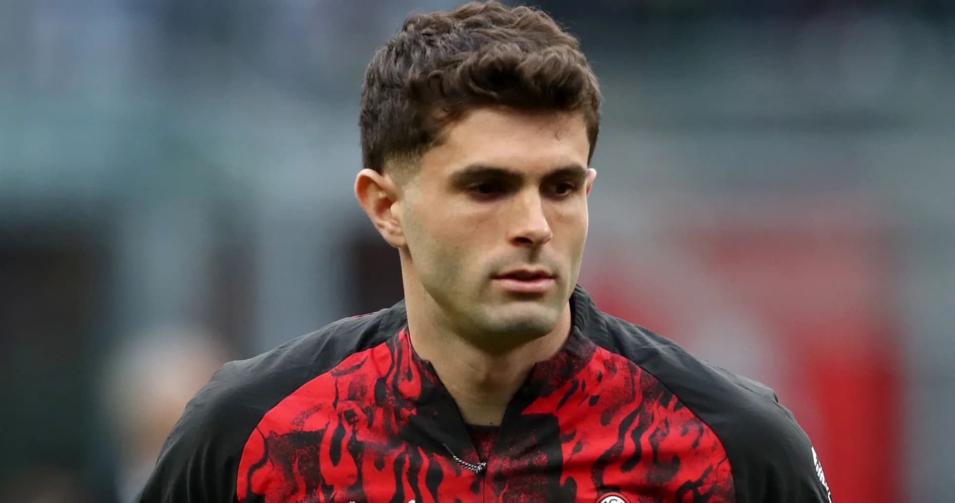Player in red and black jersey on the field Player in red and black jersey on the field