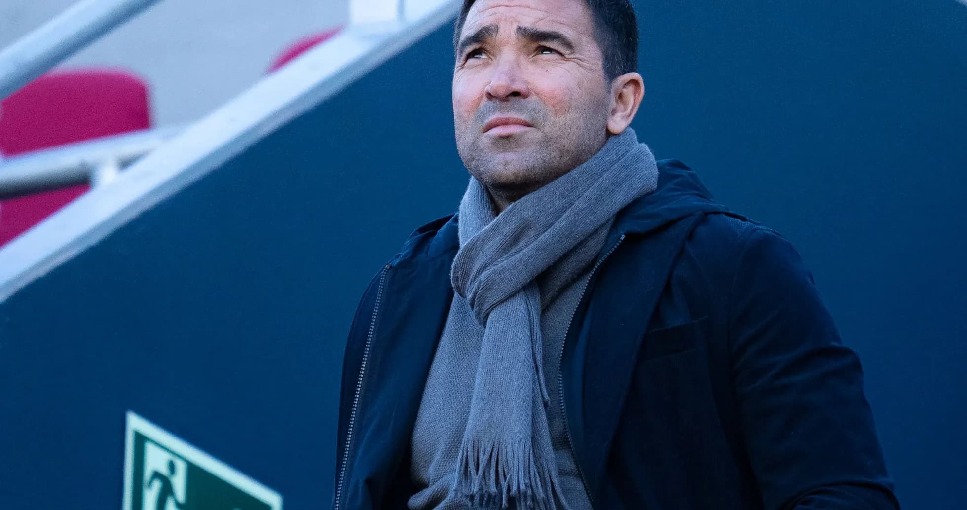 Man in a scarf looking up at stadium Man in a scarf looking up at stadium