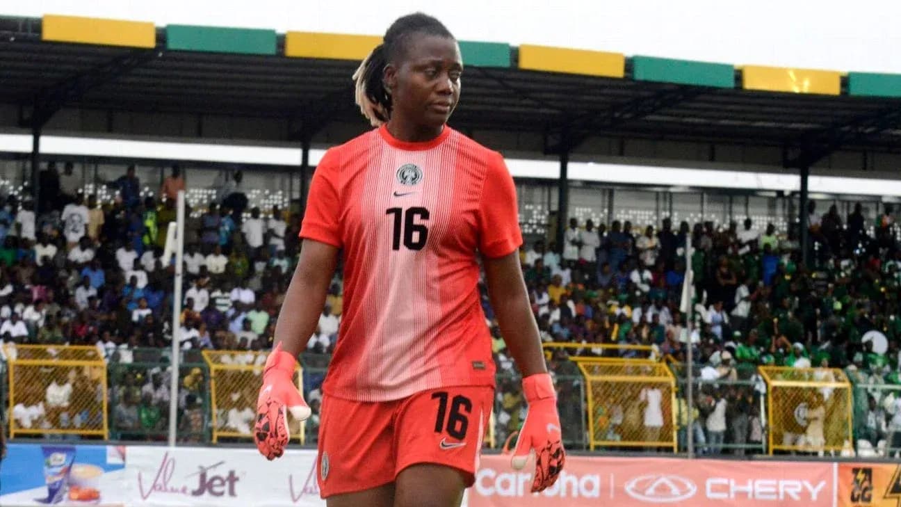 Goalkeeper in red kit walking on field Goalkeeper in red kit walking on field