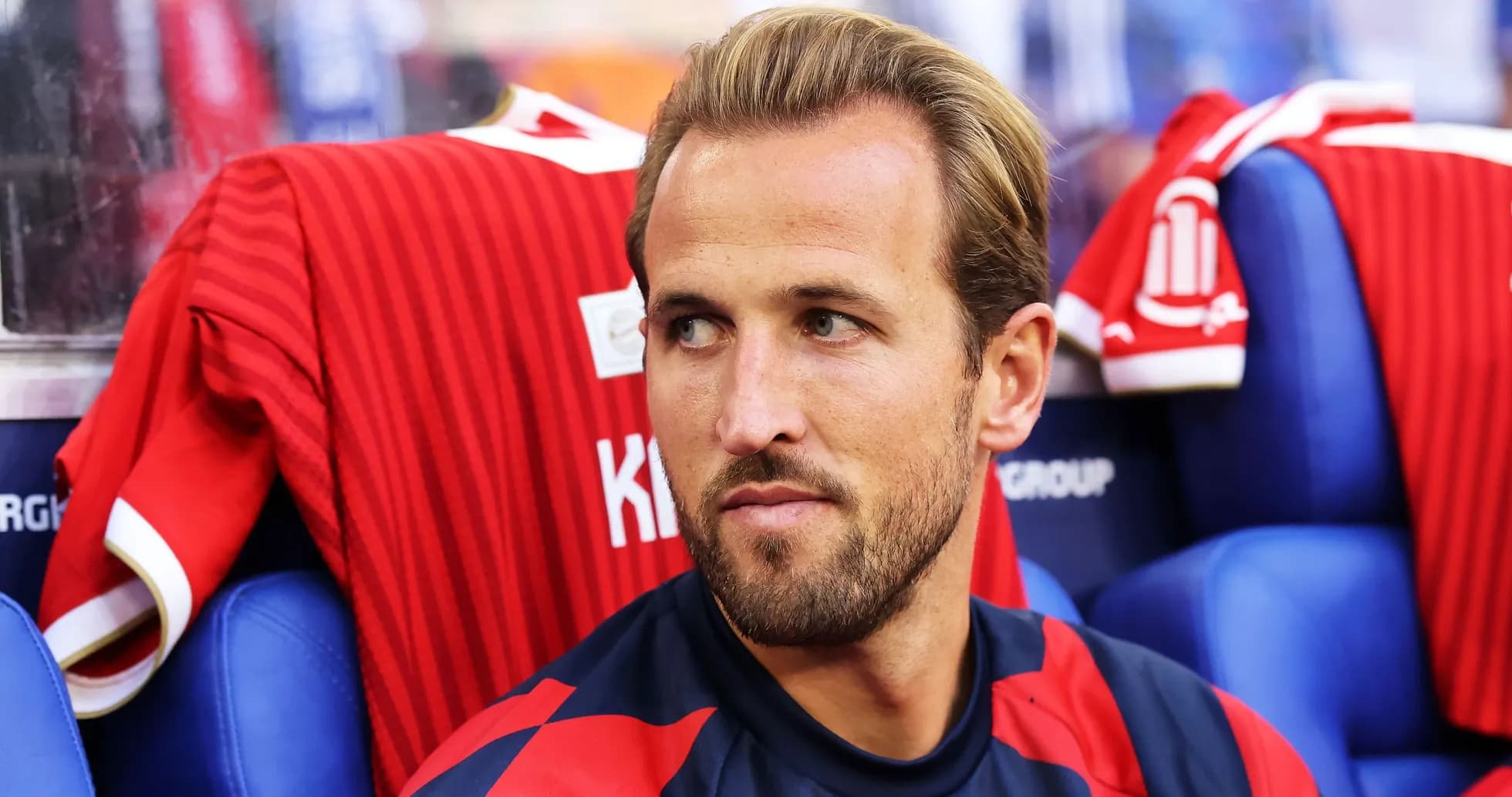 Player sitting on bench with red jersey in background Player sitting on bench with red jersey in background