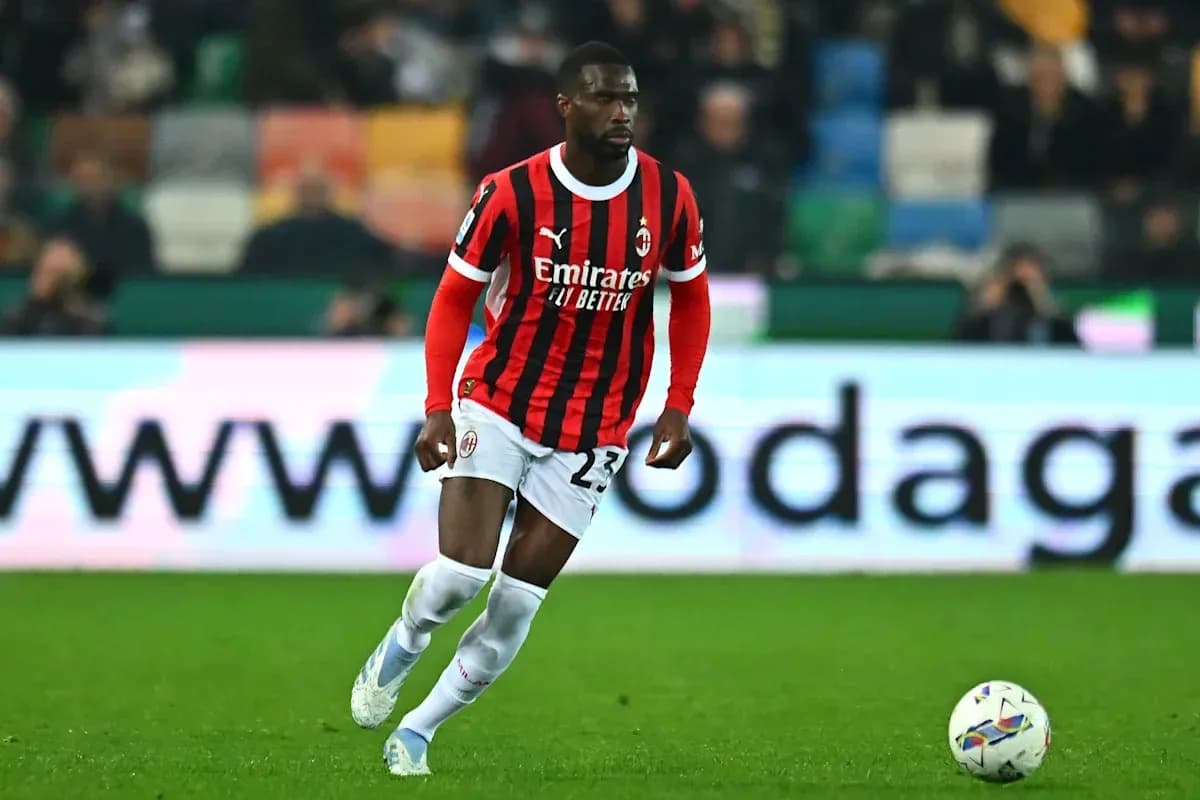 Player in AC Milan kit dribbling ball on field Player in AC Milan kit dribbling ball on field