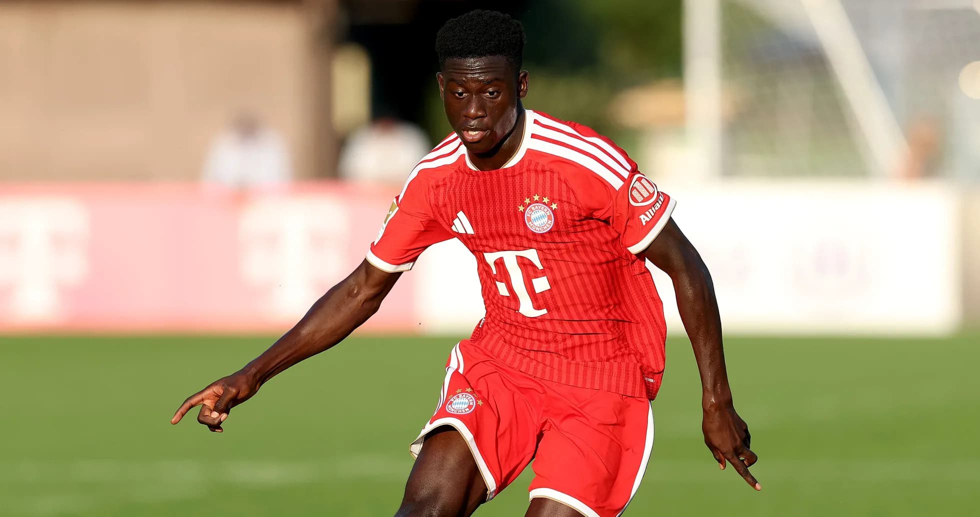 Player in Bayern Munich kit running on the field Player in Bayern Munich kit running on the field