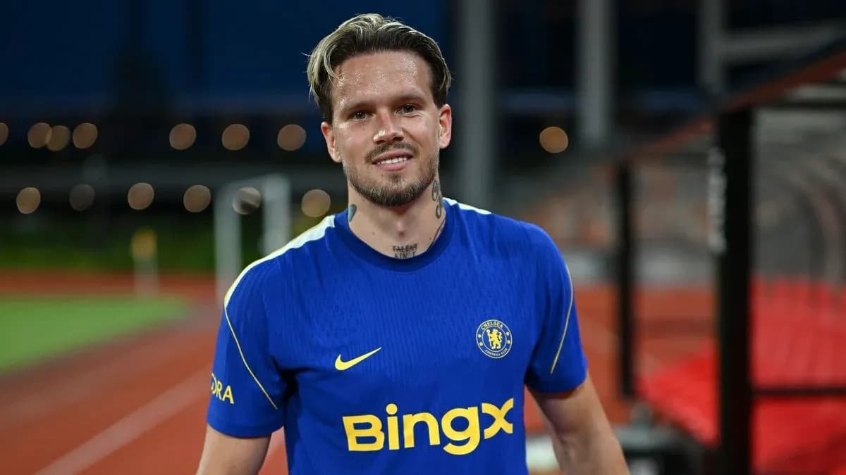 Player in Chelsea jersey smiling on the pitch Player in Chelsea jersey smiling on the pitch