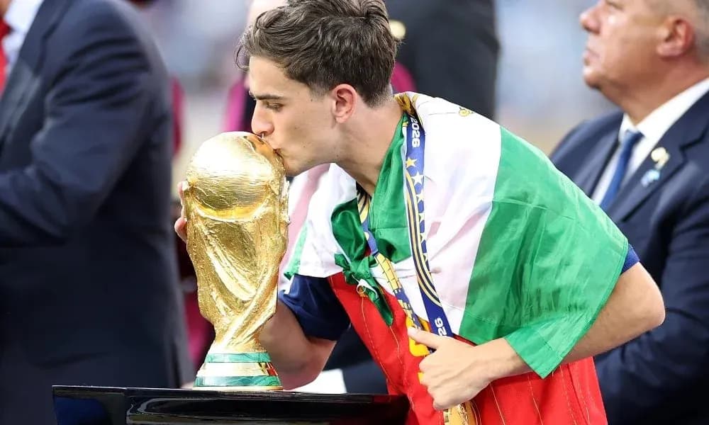 Player kissing World Cup trophy while wrapped in flag Player kissing World Cup trophy while wrapped in flag